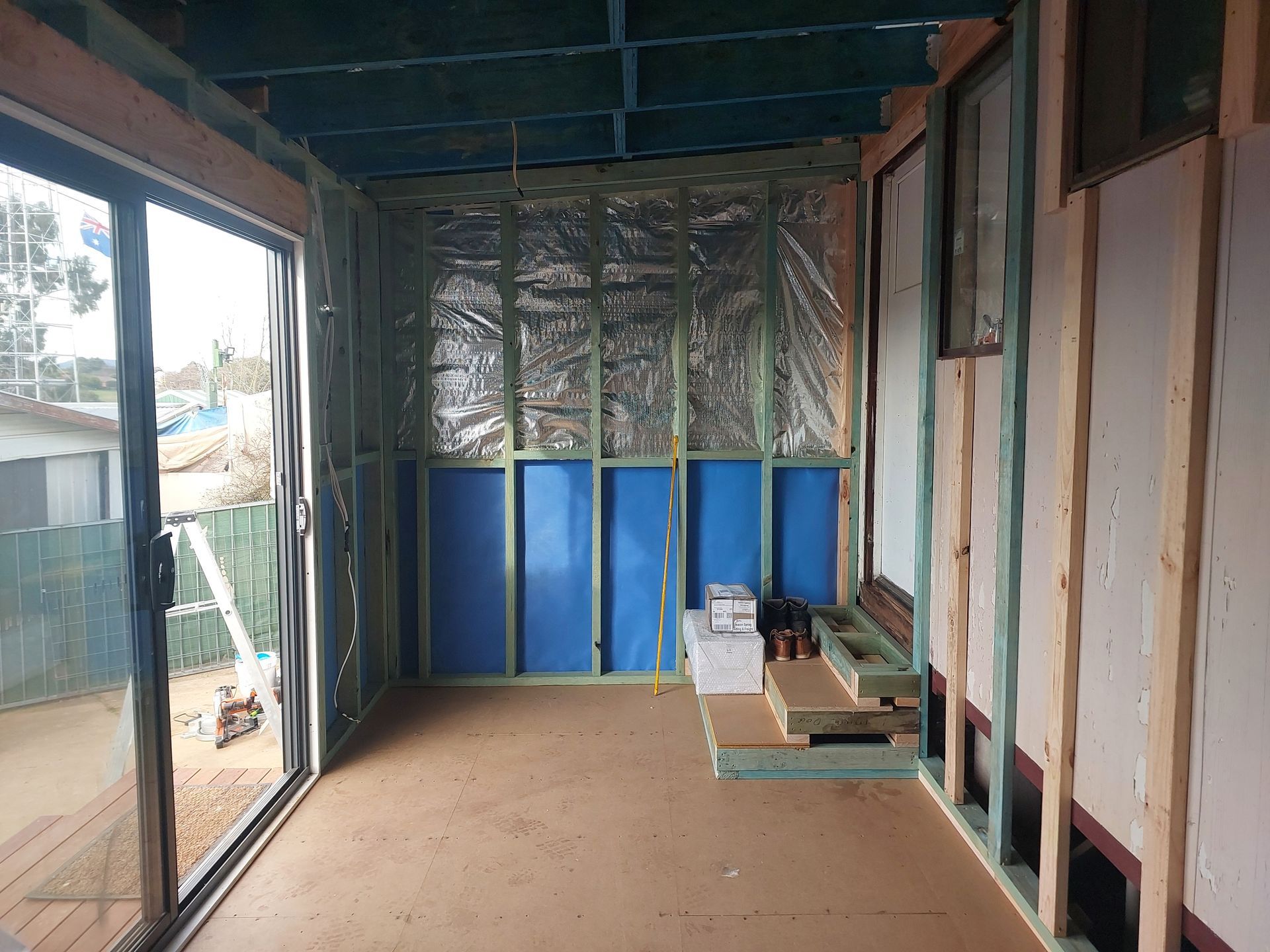 Interior of a Room Under Construction, With Wooden Framing, Insulation, and a Sliding Glass Door — Elimar Construction in Goulburn, NSW