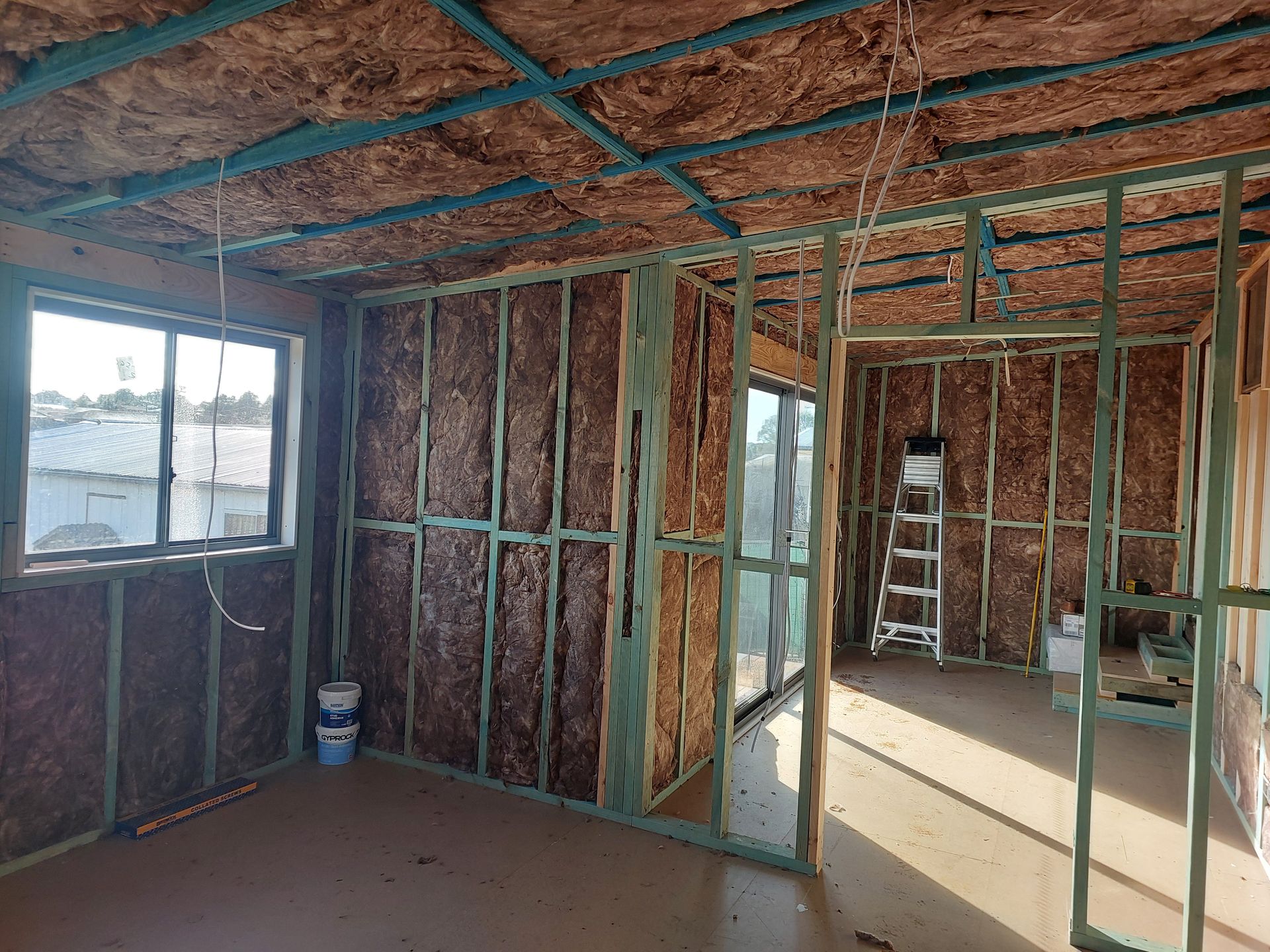 Interior of a Building Under Construction, With Wood Framing, Insulation, and a Window — Elimar Construction in Goulburn, NSW