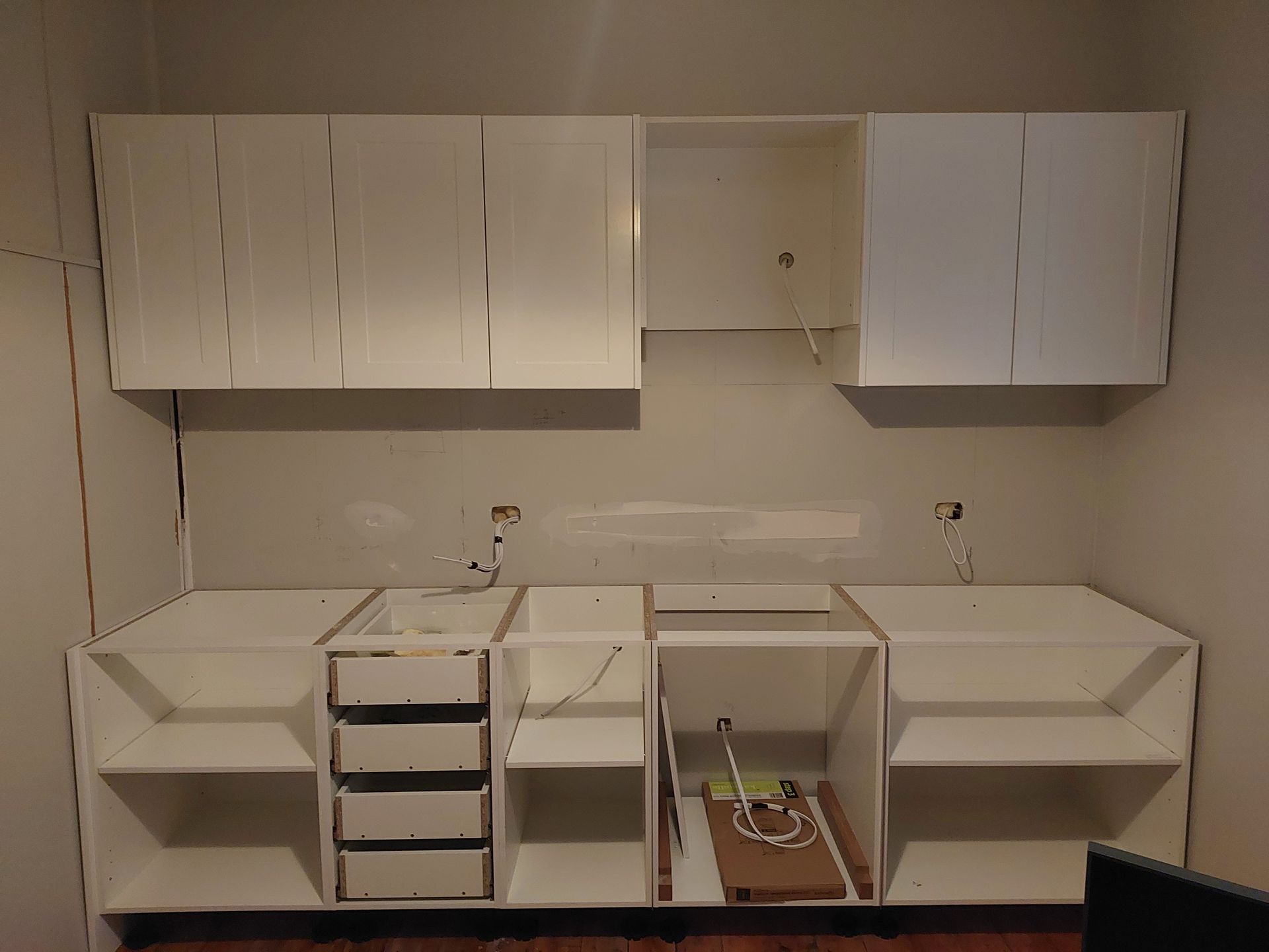 A Kitchen Under Construction With White Cabinets and Drawers — Elimar Construction in Goulburn, NSW