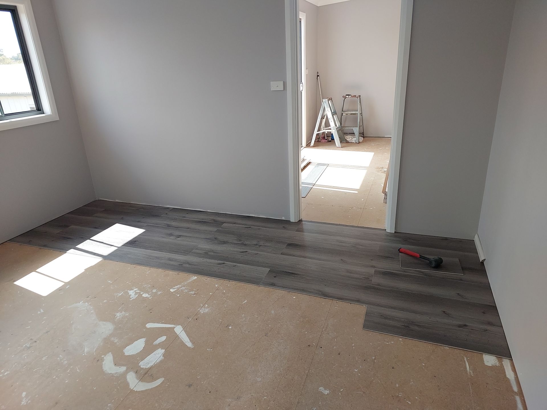 Room With Gray Walls and Wood-look Flooring Being Installed; Partially Completed — Elimar Construction in Goulburn, NSW