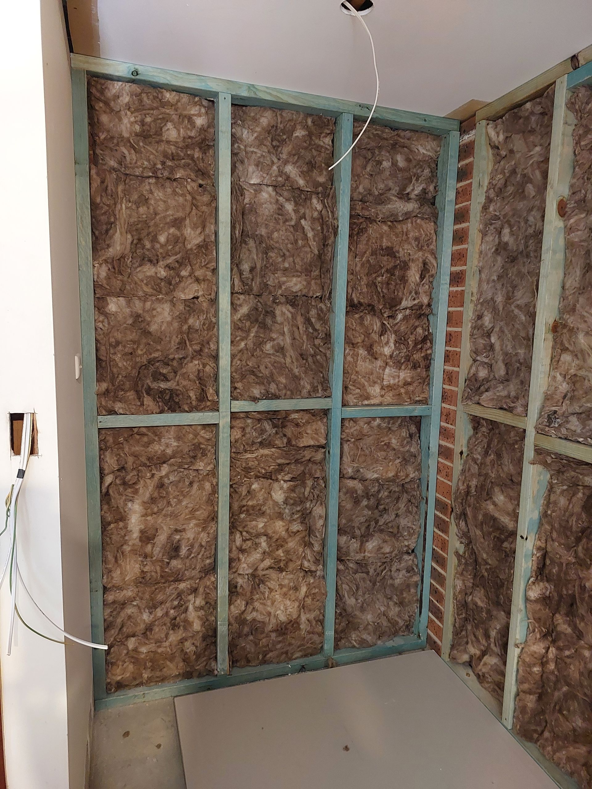 Interior Wall Under Construction; Wooden Frame With Insulation, Brick and Drywall Visible — Elimar Construction in Goulburn, NSW