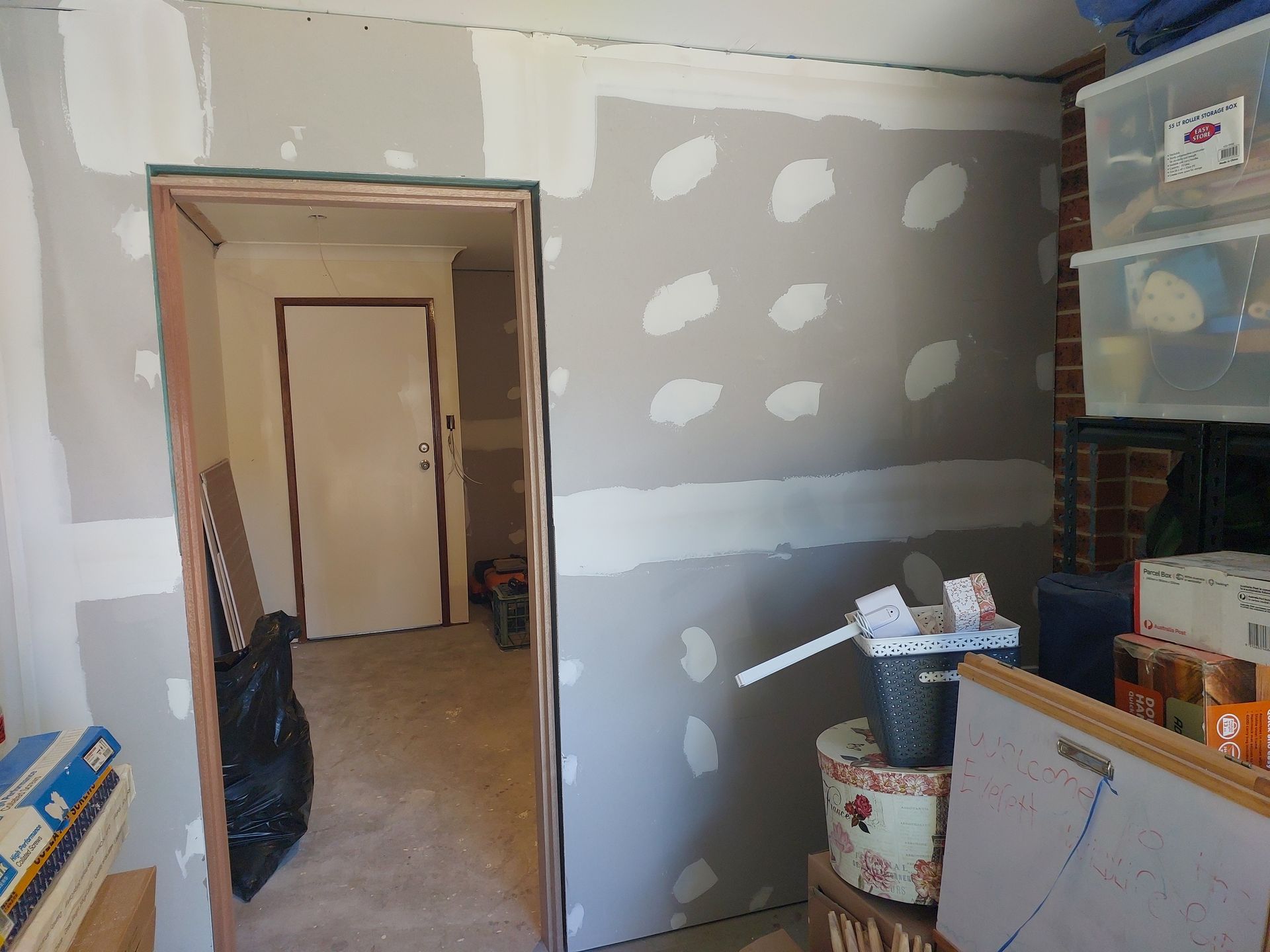 Interior Room With Unfinished Drywall; Door Frame; Storage Containers; Brick Chimney — Elimar Construction in Goulburn, NSW