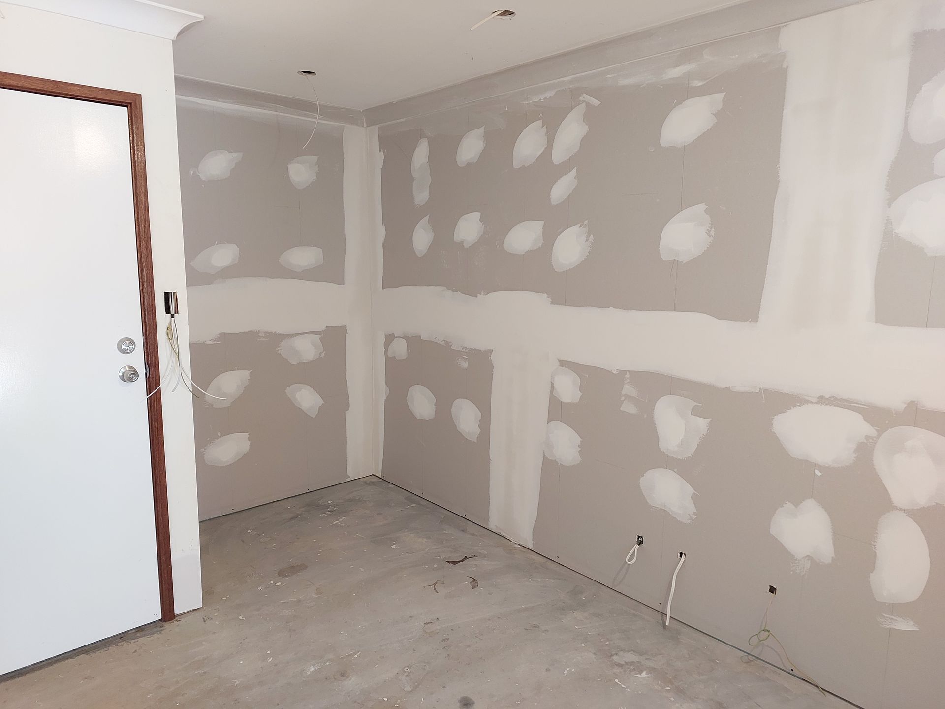 Interior Room Under Construction, With Drywall, Mud, and Door. Grey Walls, Light Floor — Elimar Construction in Goulburn, NSW