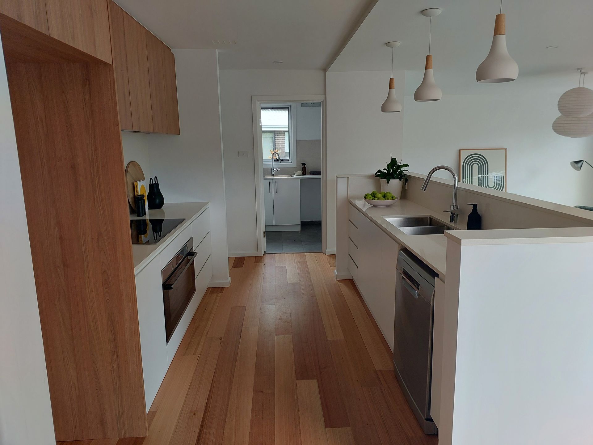 Modern Kitchen With Wooden Floors, White Cabinets, and Stainless Steel Appliances — Elimar Construction in Goulburn, NSW