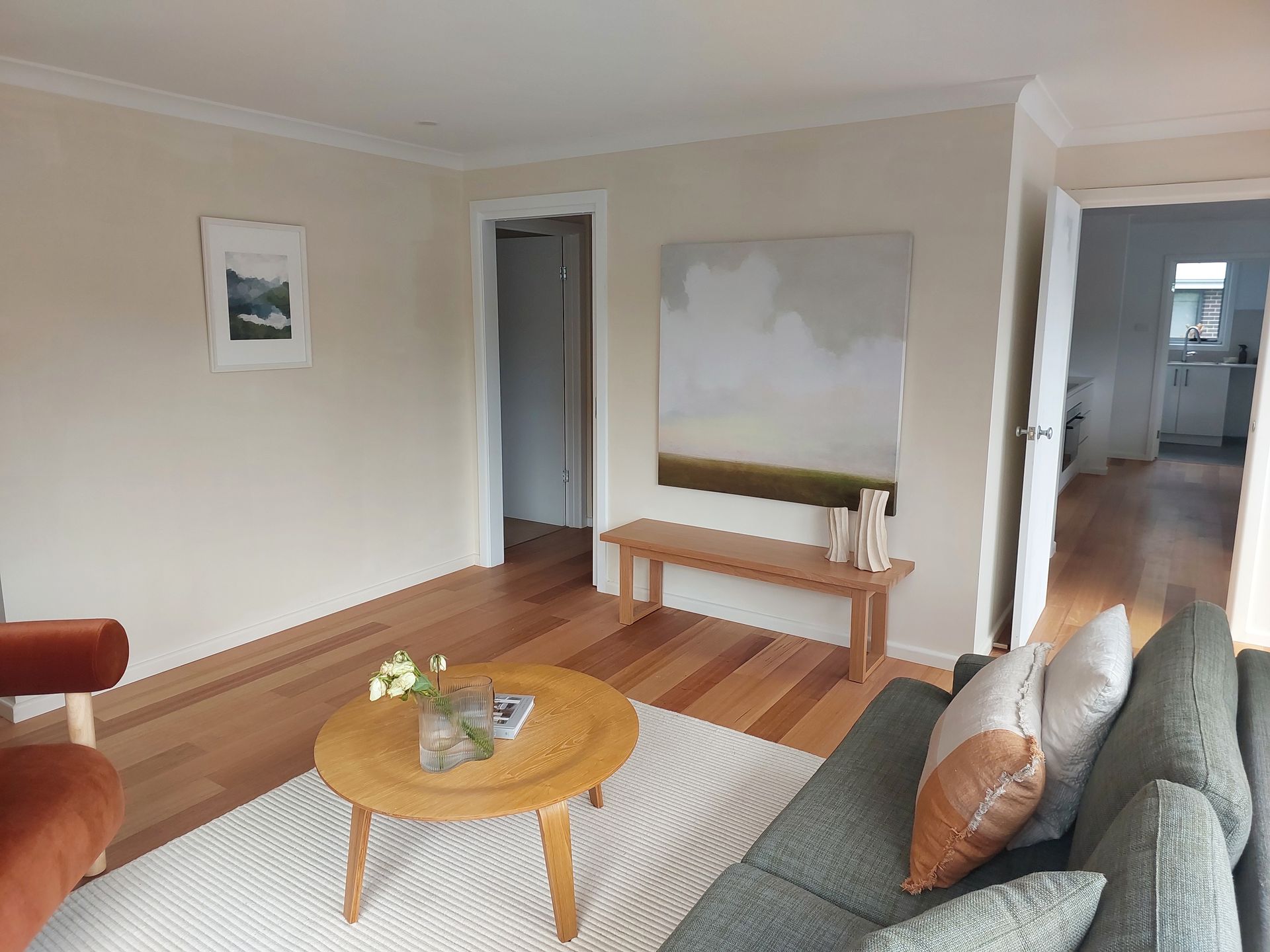 Living Room With Light-colored Walls, Wooden Floor, and a Modern Painting Above a Wooden Bench — Elimar Construction in Goulburn, NSW