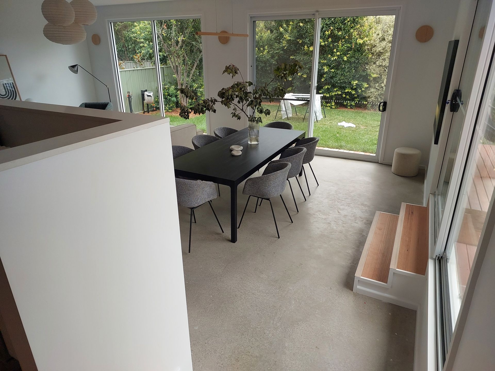 Dining Room With Dark Table and Chairs, Sliding Glass Doors to a Yard, and a Partial View of Steps — Elimar Construction in Goulburn, NSW