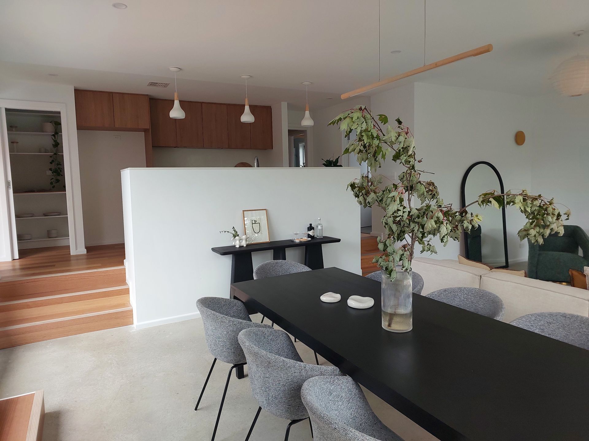 Modern Dining Room With a Black Table, Gray Chairs, and an Open Kitchen — Elimar Construction in Goulburn, NSW