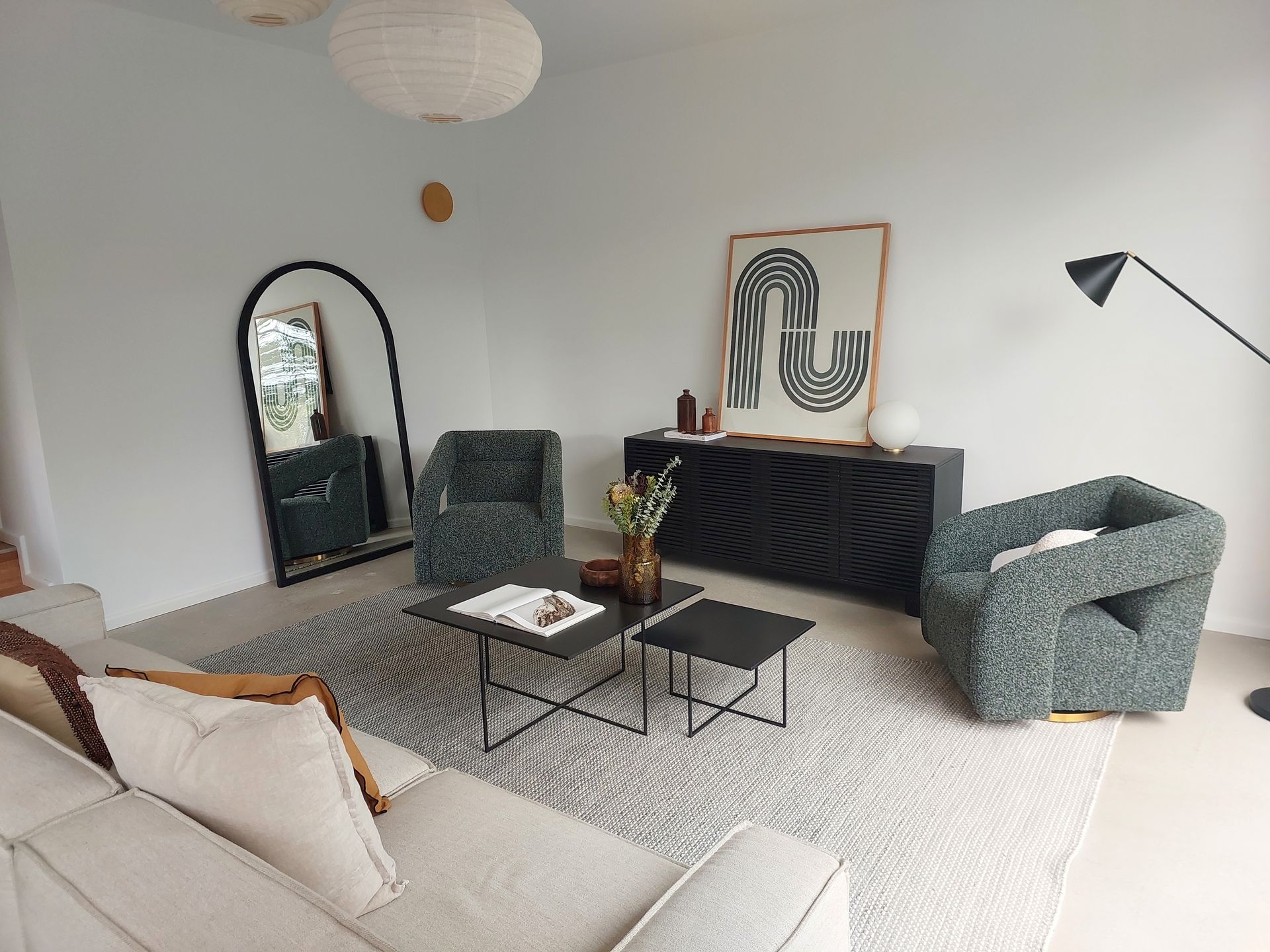 Living Room With Cream Sofa, Two Patterned Armchairs, Black Coffee Tables, and a Large Arched Mirror — Elimar Construction in Goulburn, NSW