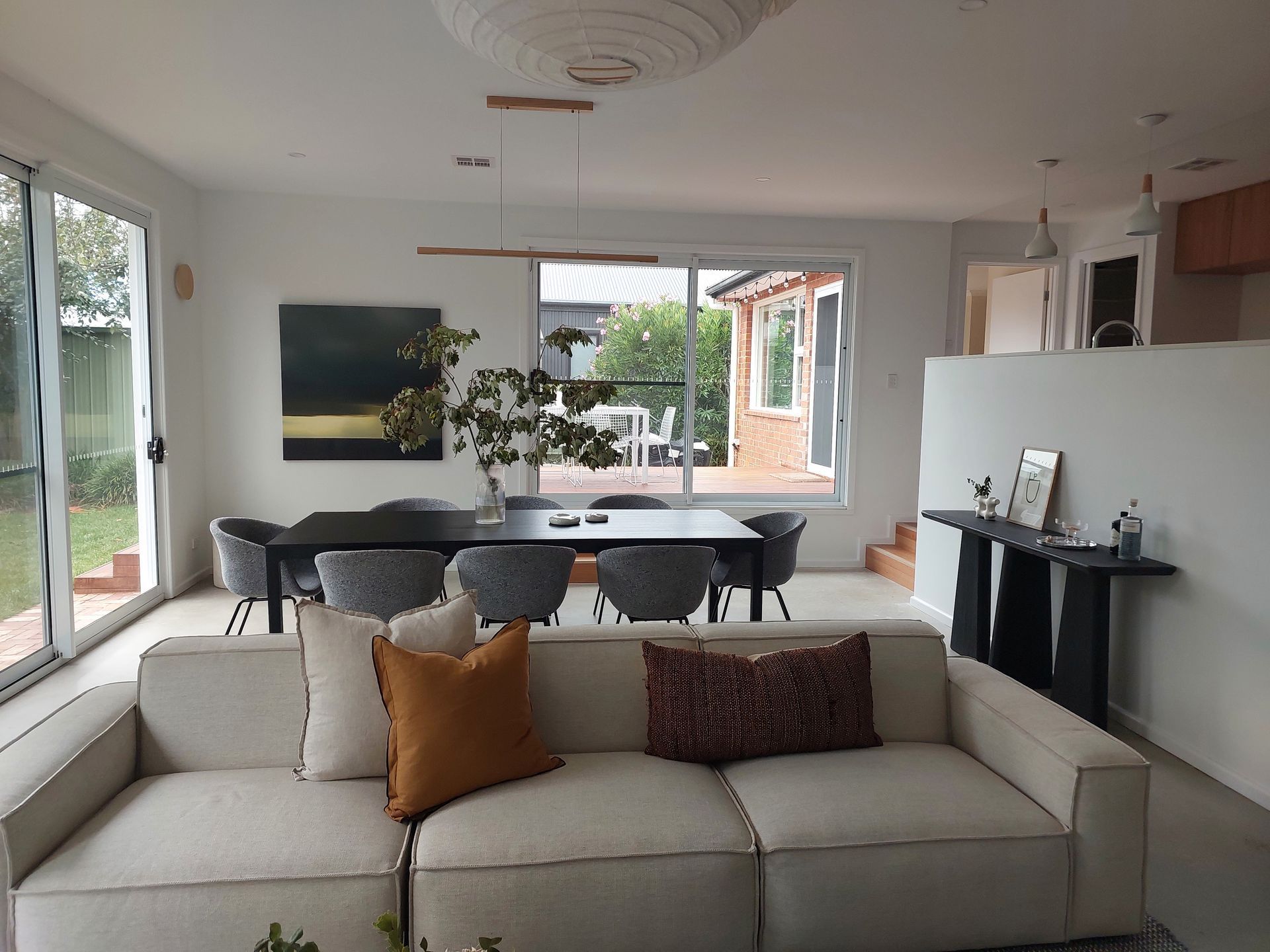 Living Room With Couch, Dining Table, and Sliding Glass Doors.  Modern Decor, Neutral Colors, and Natural Light — Elimar Construction in Goulburn, NSW