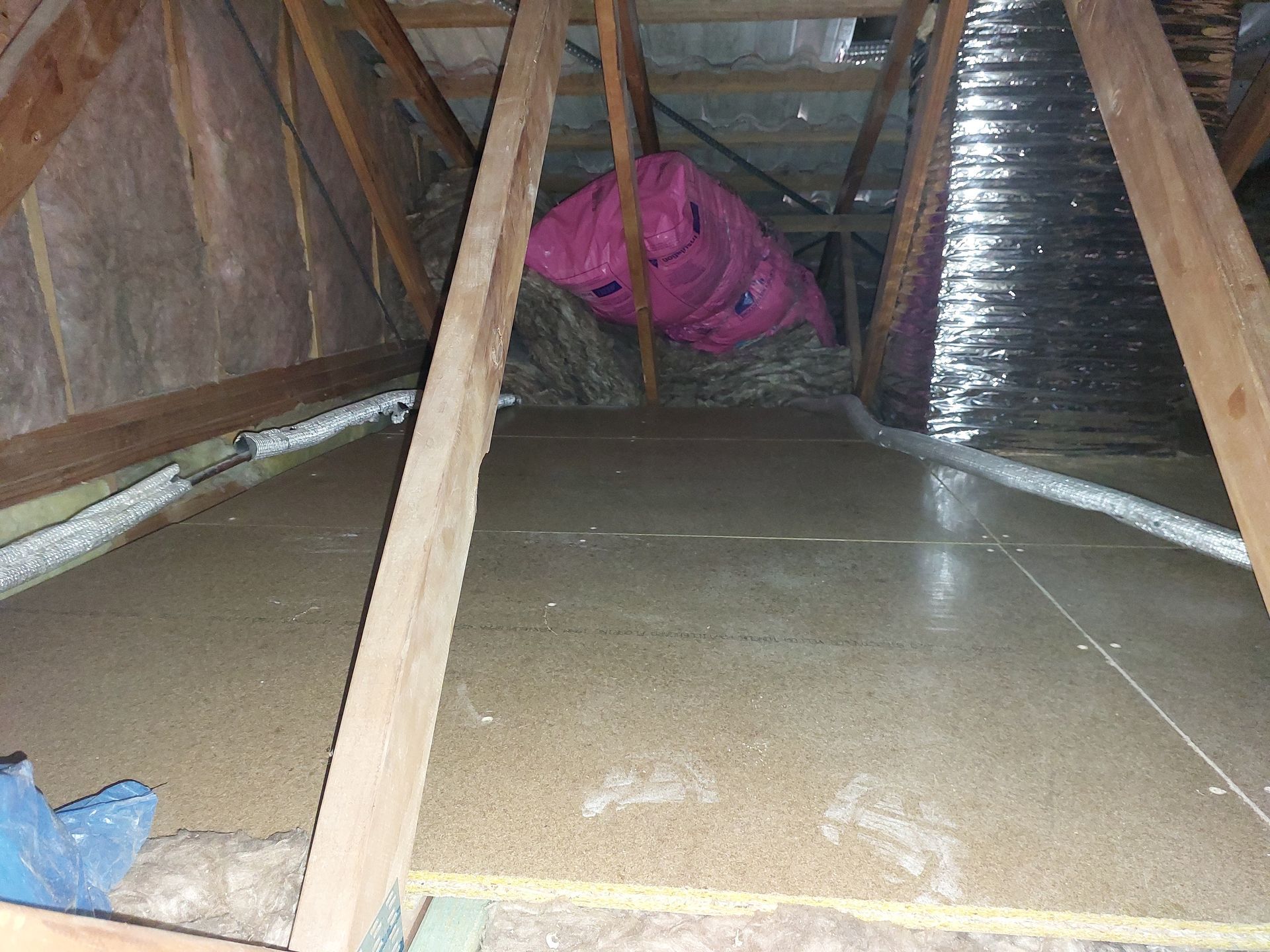 Attic Interior: Plywood Flooring, Wooden Beams, Insulation, Pink Tarp, and Ductwork  — Elimar Construction in Goulburn, NSW