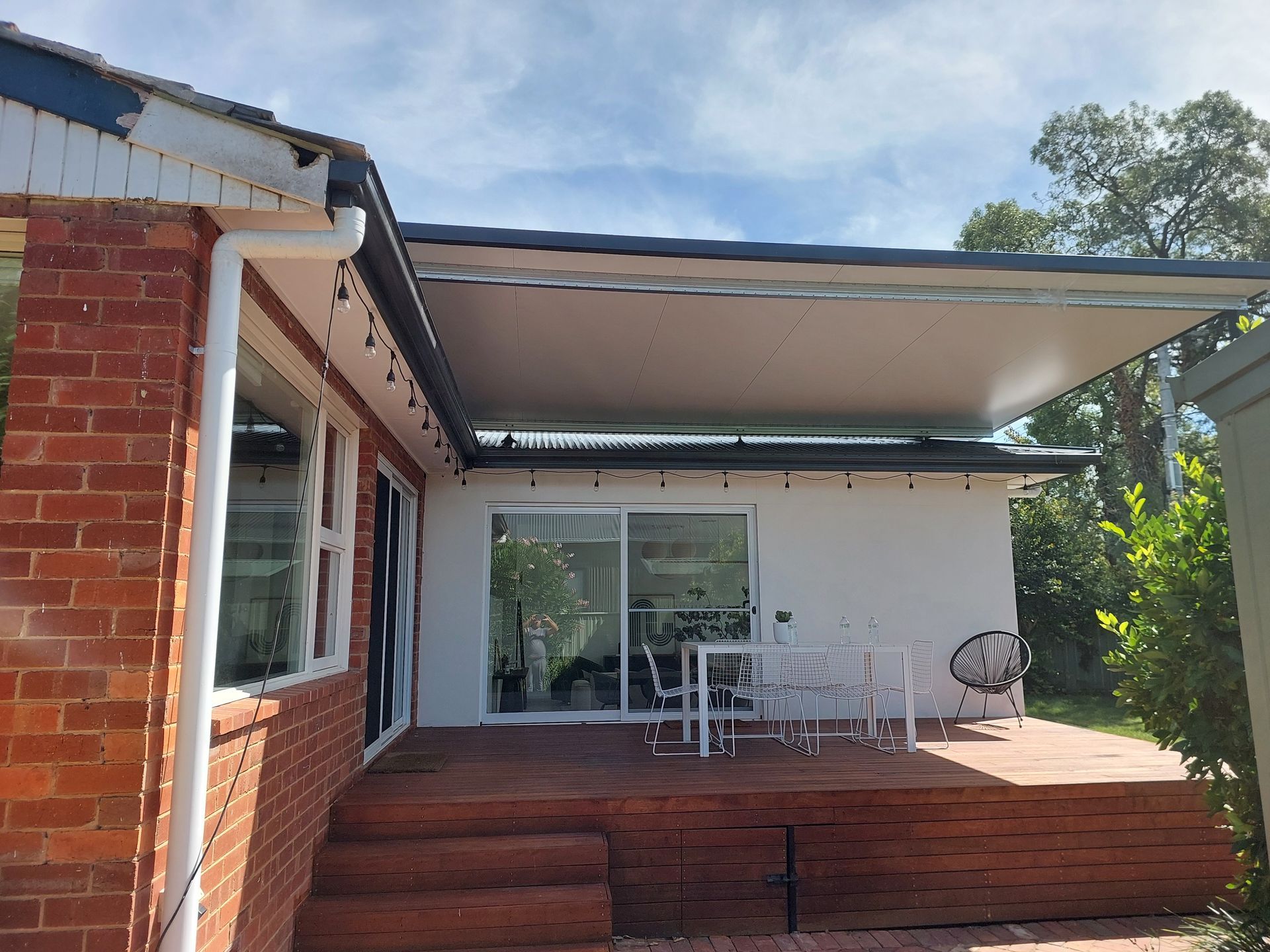 Outdoor Patio With a White Awning, Red Brick House, and Wooden Deck — Elimar Construction in Goulburn, NSW