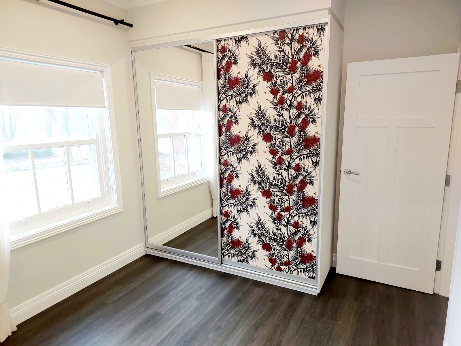 Bedroom With Mirrored Closet Doors and Floral Design, Two Windows, and Dark Wood Flooring  — Elimar Construction in Goulburn, NSW