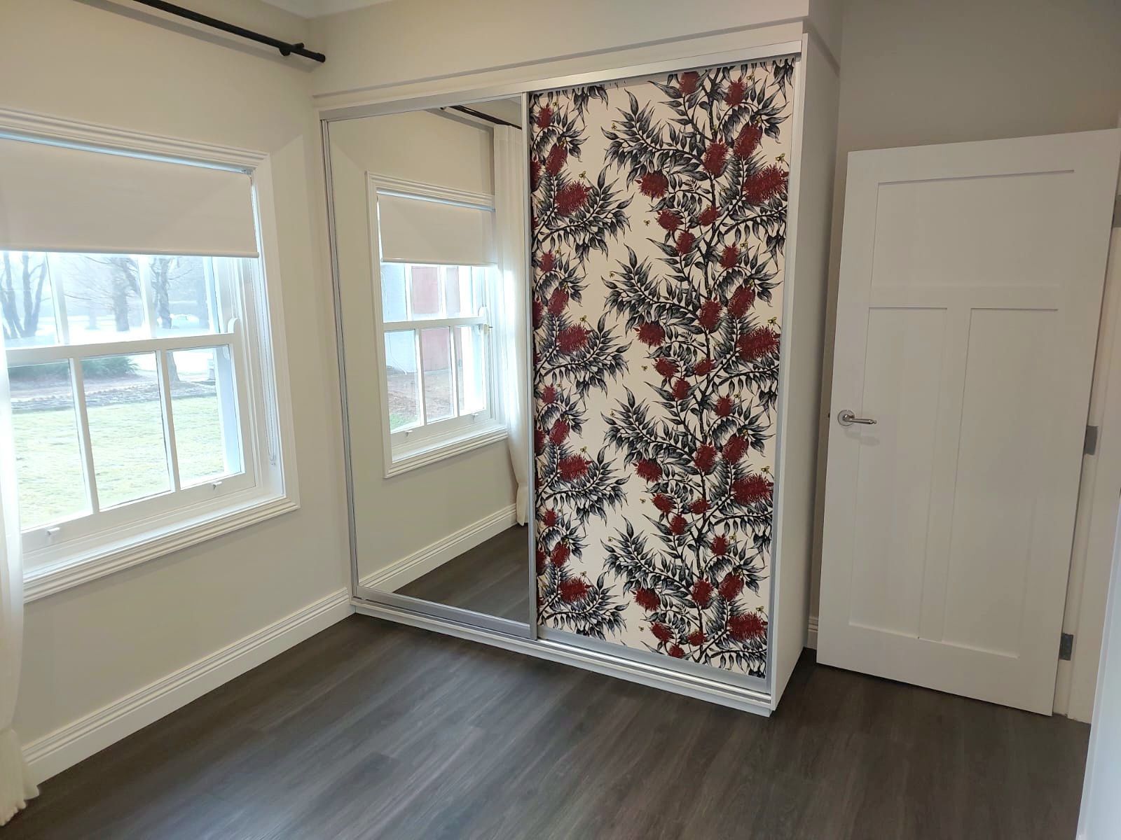 Bedroom With Mirrored Sliding Closet Doors and Floral Patterned Panel  — Elimar Construction in Goulburn, NSW