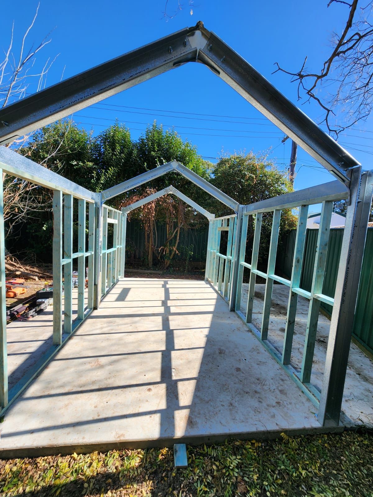Metal Framing for a Shed Structure on a Concrete Slab, With a Blue Sky Background — Elimar Construction in Goulburn, NSW