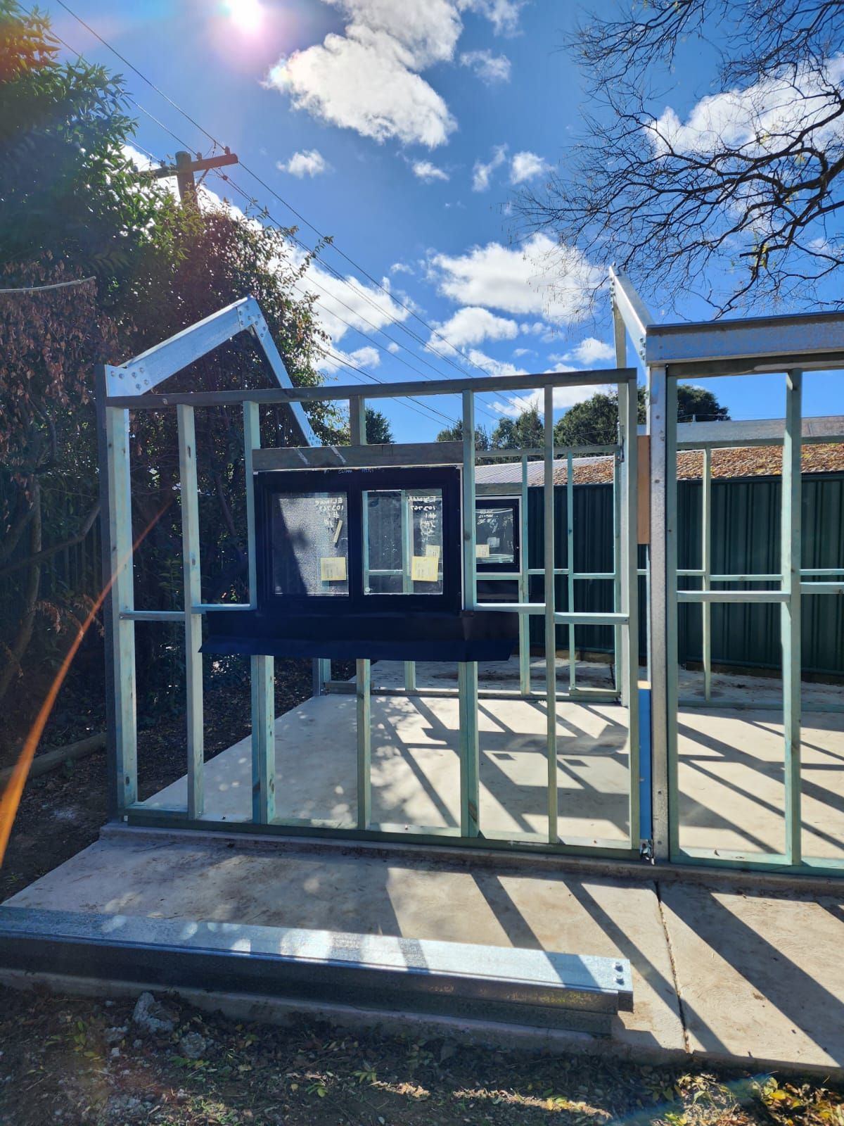 Framed Walls of a Building Under Construction, a Window Installed, Blue Sky Visible — Elimar Construction in Goulburn, NSW