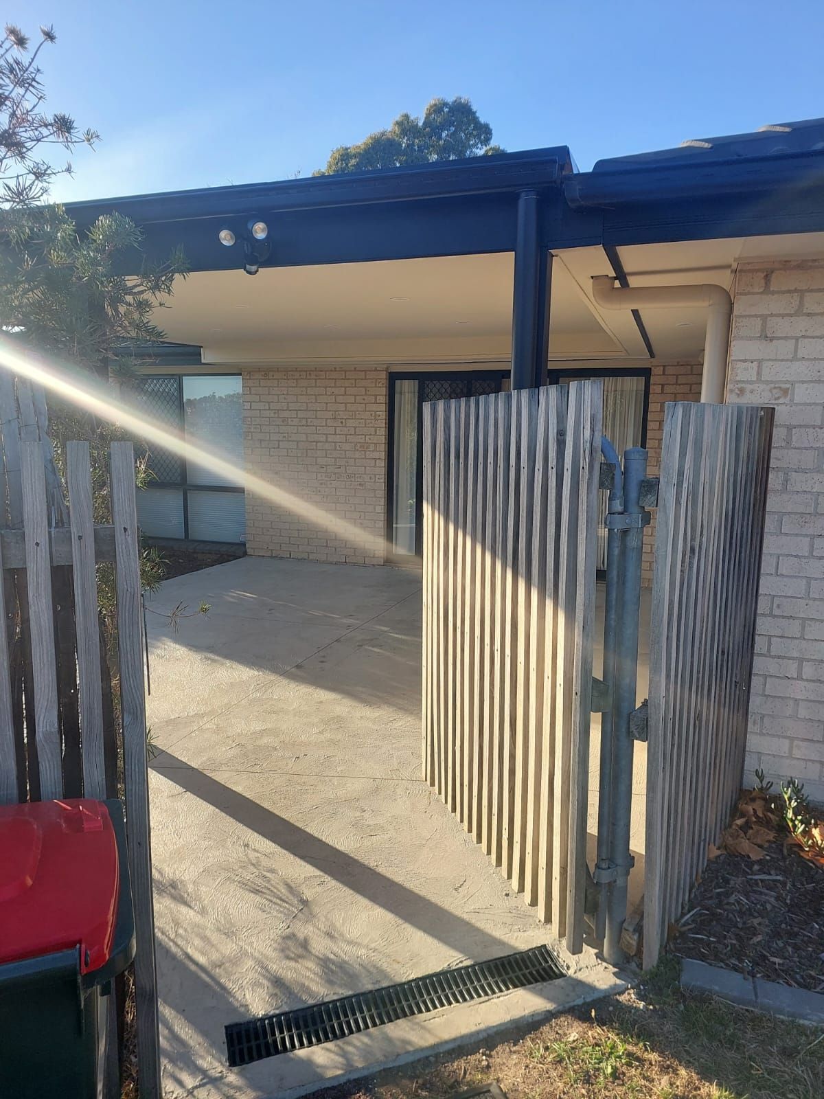 Entrance to a House With a Concrete Path, Corrugated Fence, and Covered Porch — Elimar Construction in Goulburn, NSW