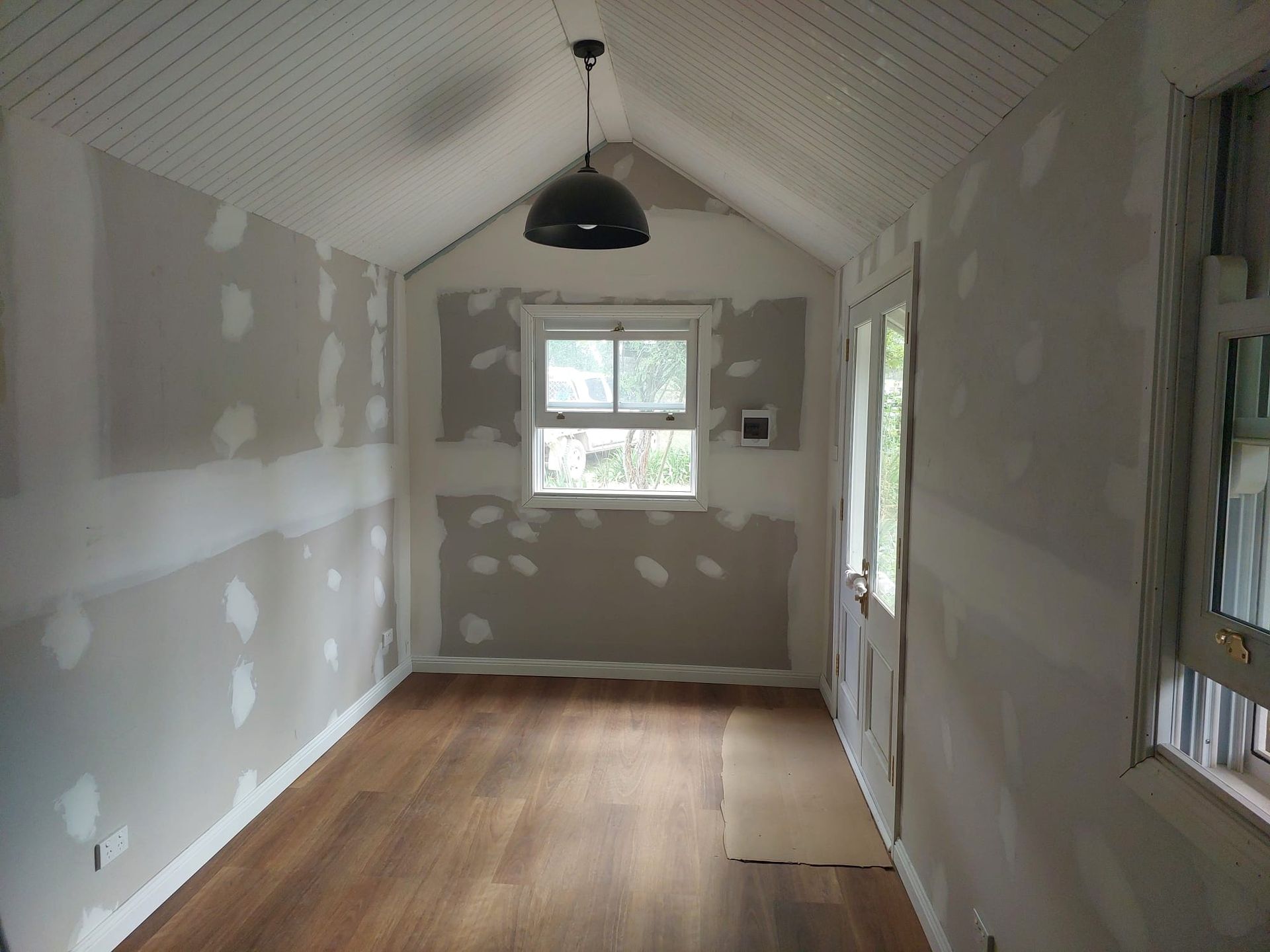 Interior Room Under Renovation, With Drywall on Walls and Ceiling, Wood Flooring, and a Window — Elimar Construction in Goulburn, NSW