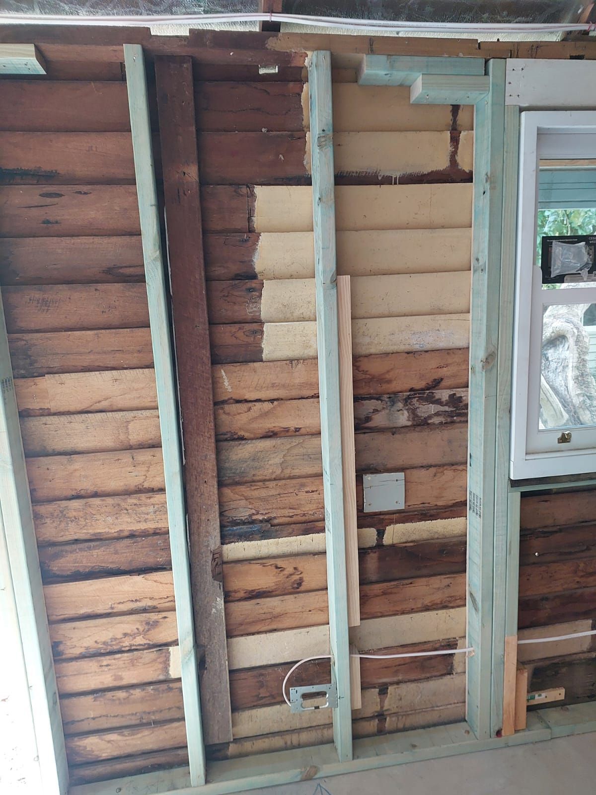 Interior Wall Undergoing Renovation, Showing Exposed Wooden Planks and Studs. Wires and Window Are Visible — Elimar Construction in Goulburn, NSW