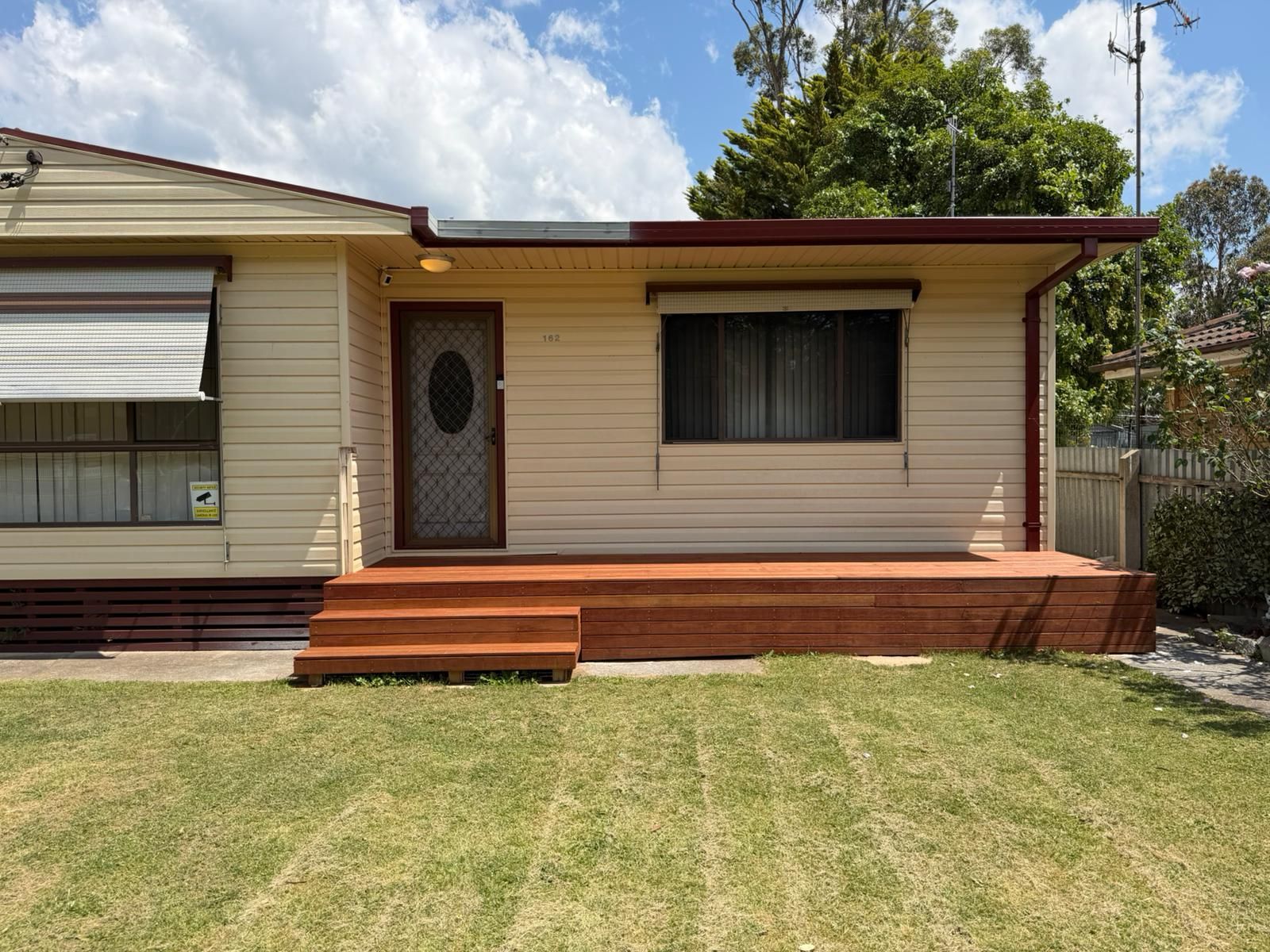 Single-story beige house with a front porch and steps, set behind a green lawn — Elimar Construction in Goulburn, NSW