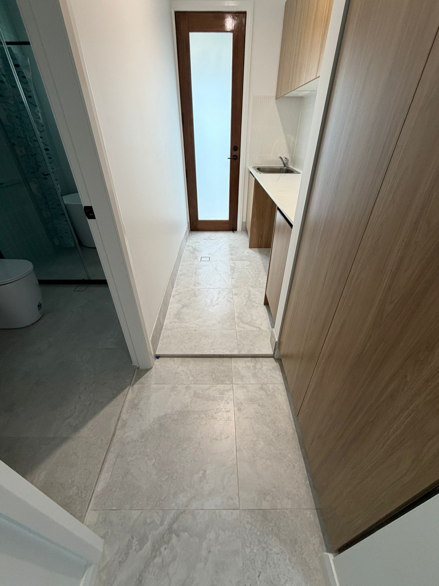 Narrow hallway with tiled floor, a narrow window at the end, and a small sink on the right — Elimar Construction in Goulburn, NSW