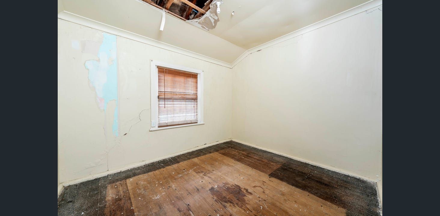 Empty Room With Damaged Ceiling, Walls, and Wooden Floor. Window With Blinds  — Elimar Construction in Goulburn, NSW