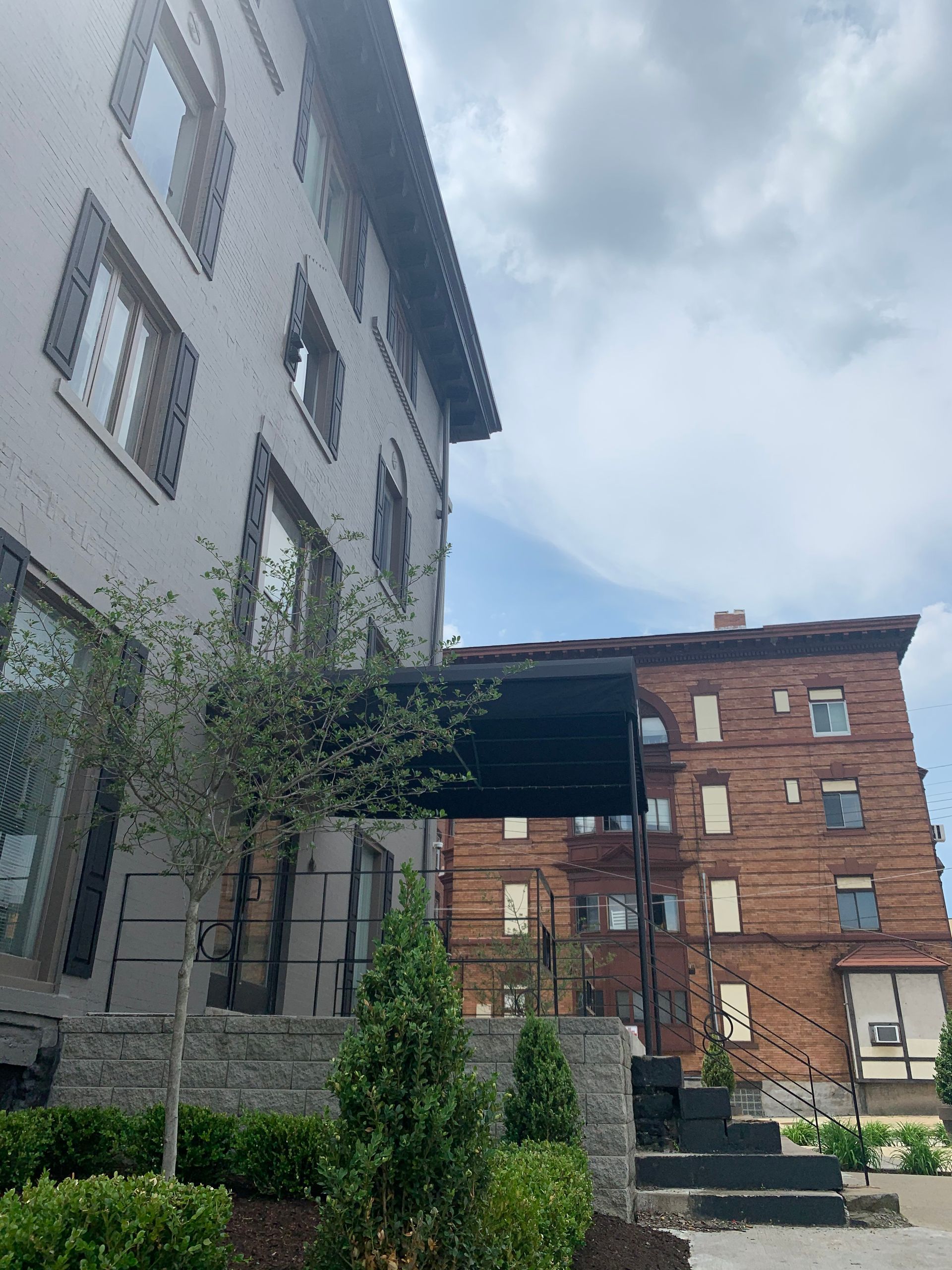 Buildings with brick and painted exteriors under a cloudy sky.