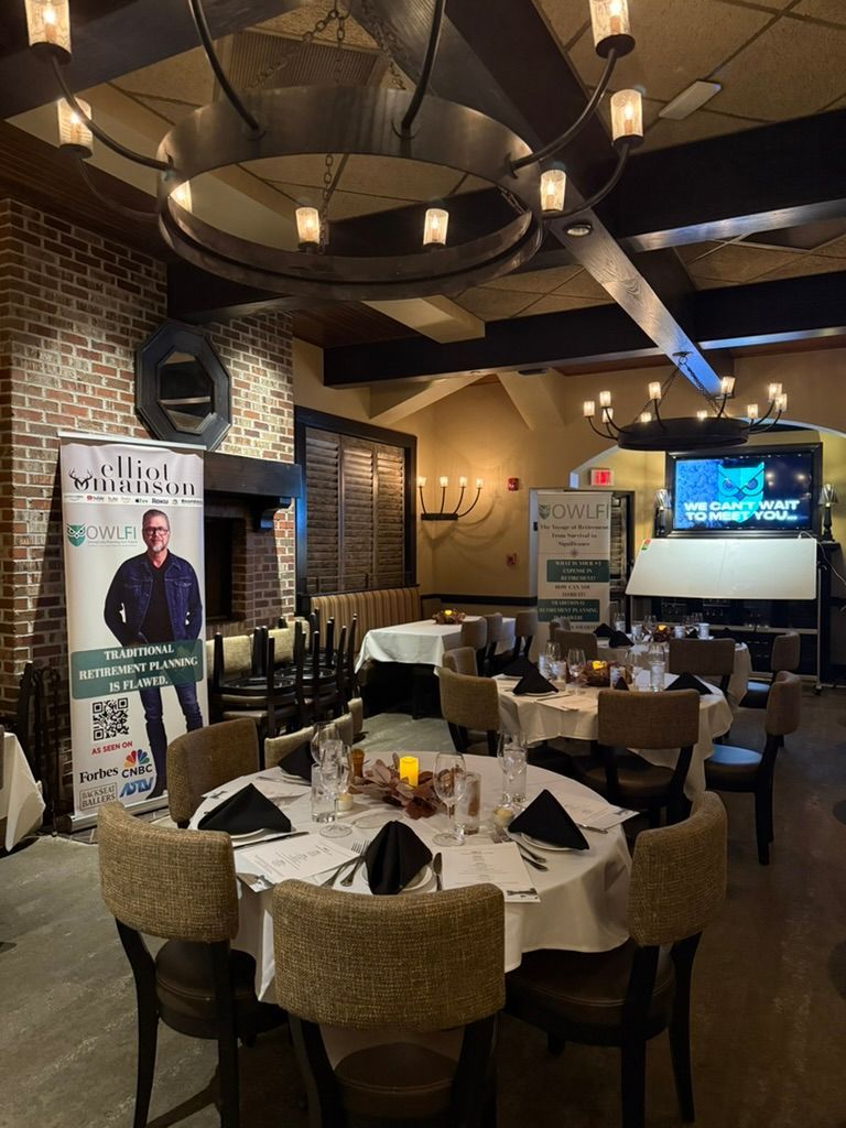 Restaurant dining room with round tables set for guests; banner ad in view.