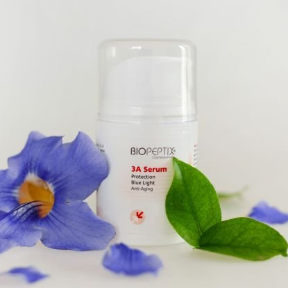 A bottle of biopeptide 3a serum next to a flower