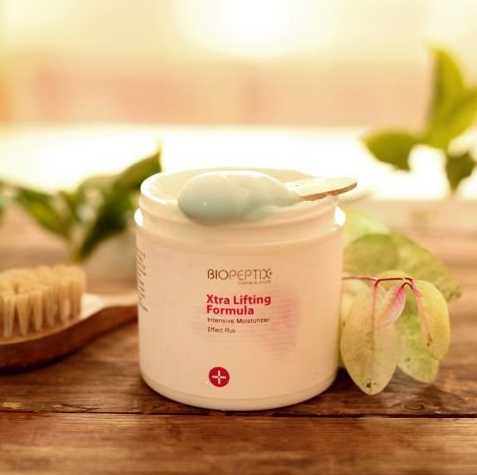 A jar of biopeptide xtra lifting formula with a spoon in it