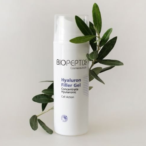 A bottle of biopeptix hyaluron filler gel is sitting next to a plant.