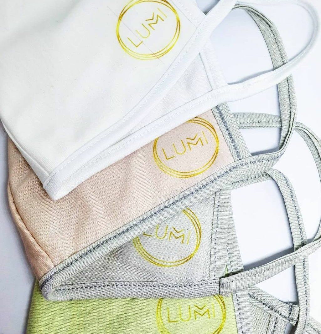 Three face masks are stacked on top of each other on a table.