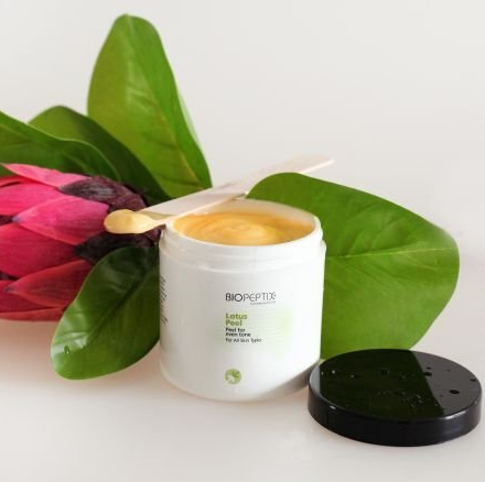 A jar of bioseptx lotion next to a flower