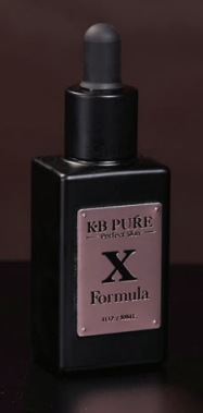 A bottle of kb pure x formula is sitting on a table.
