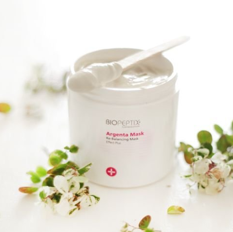 A jar of biopeptide argento mask with a spoon in it