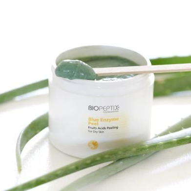 A jar of biopeptix blue enzyme peeling with a spoon in it