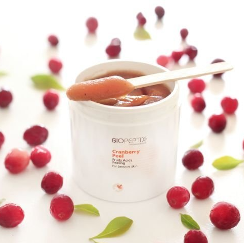 A jar of biopeptide cranberry peel with a wooden spoon in it