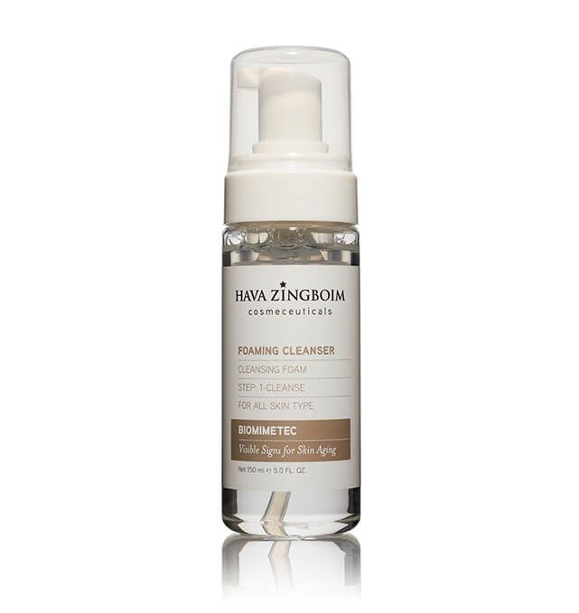 A bottle of foaming cleanser is sitting on a white surface.