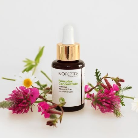 A bottle of biopeptix fourplex concentrate is surrounded by pink flowers
