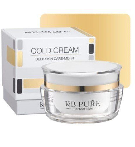 A jar of gold cream next to a box.