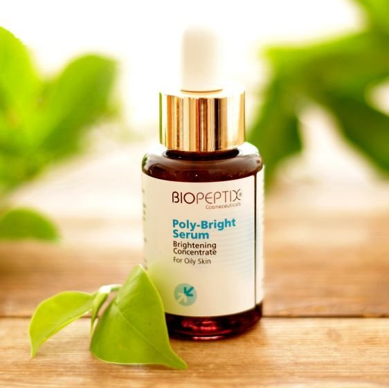A bottle of biopeptides poly-bright serum sits on a wooden table