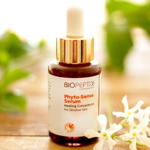 A bottle of biopeptix phyto-sense serum is sitting on a wooden table.