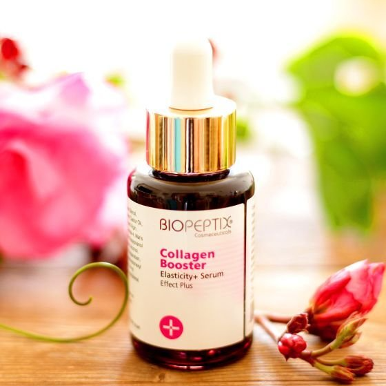 A bottle of biopeptide collagen booster is on a table