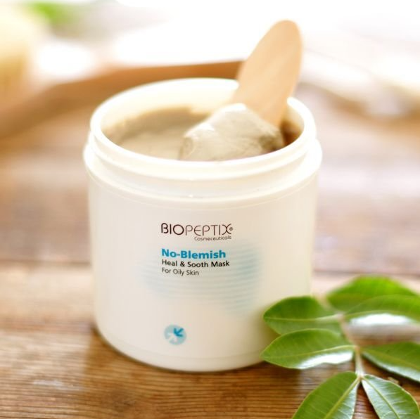 A jar of biopeptides has a wooden spoon in it