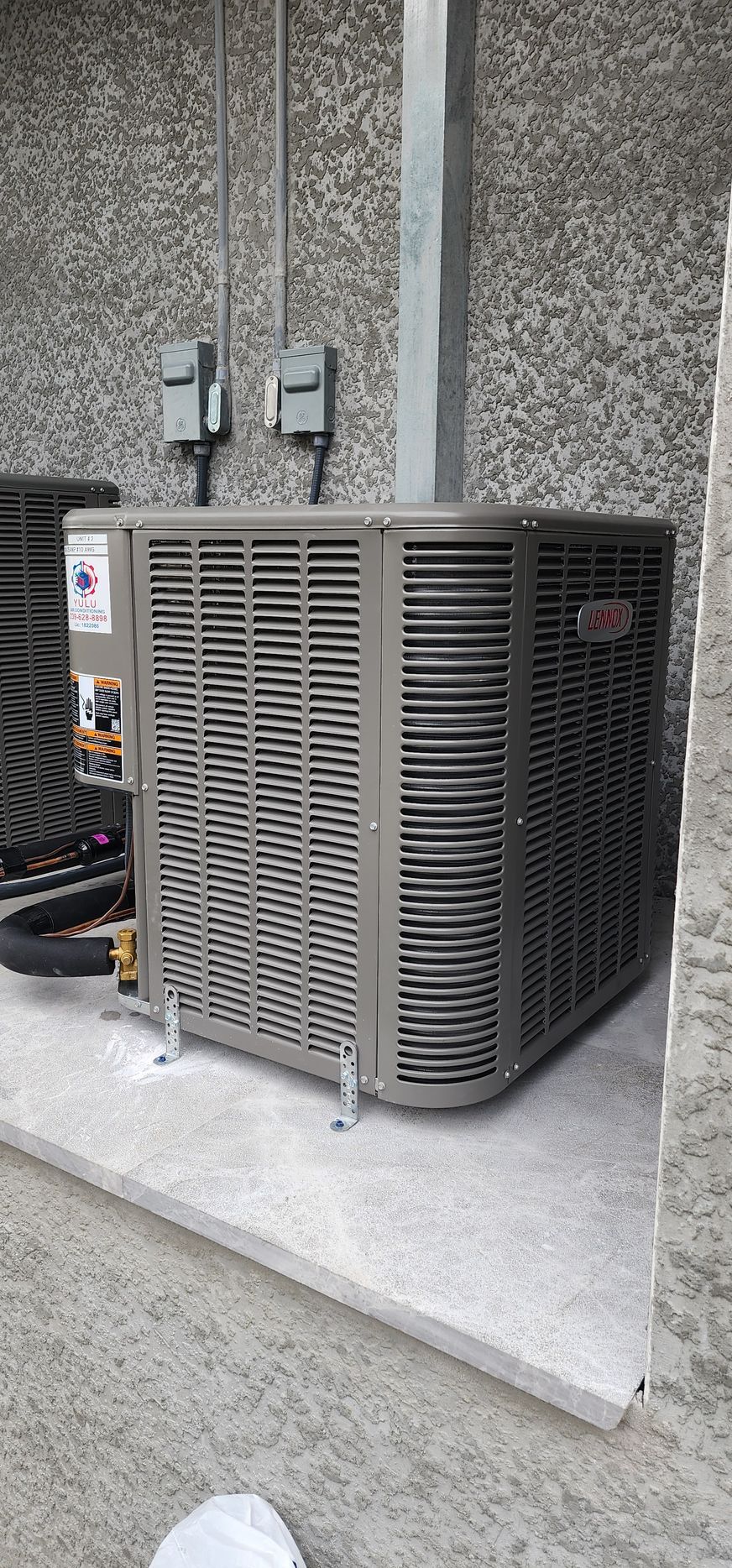 A large air conditioner is sitting on the side of a building.
