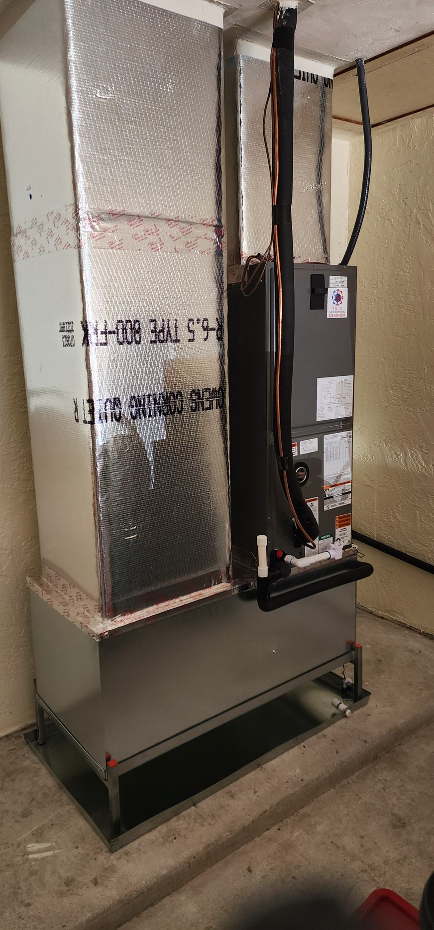 An air conditioner is sitting in a room next to a wall.