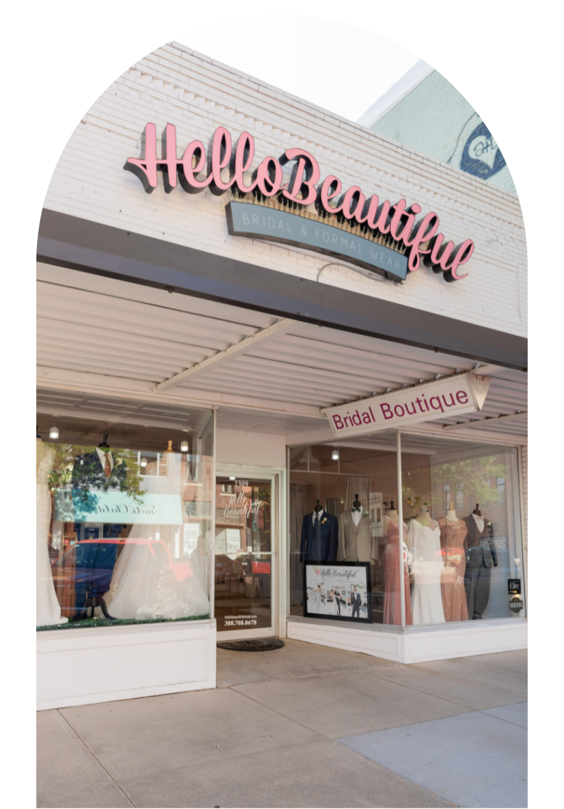 Exterior of Hello Beautiful boutique with pink sign and bridal dresses in the storefront window