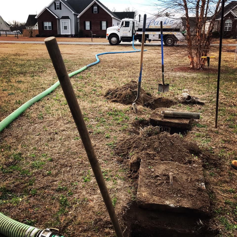 A septic tank is being installed in a yard with a truck in the background