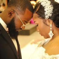 Couple in wedding attire leaning forehead to forehead during an intimate ceremony moment