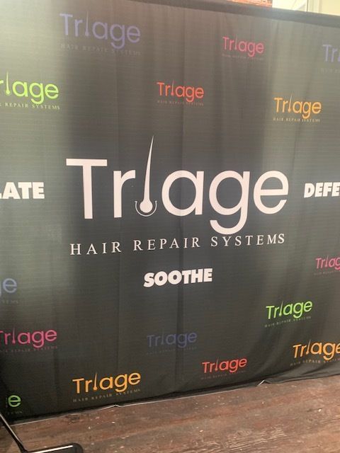 Triage Hair Repair Systems logo backdrop with repeating brand names on a black banner