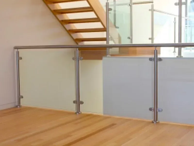 An empty room with a staircase and a glass railing